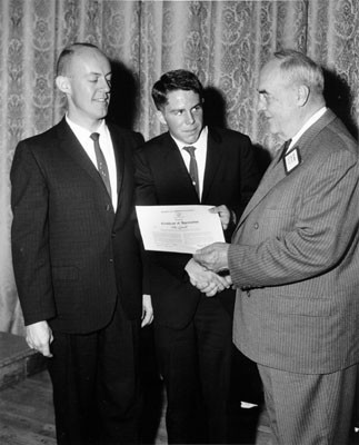 [Lowell High School student Tom Darcey being congratulated by Raymond Kohtz and Carl F. Wente for winning a journalism contest]
