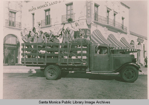 A "stick bed" truck loaded with Boy Scouts in front of the Pacific Palisades Business Block in Pacific Palisades