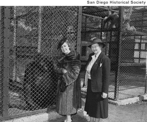 Osa Johnson and Belle Benchley standing next to a gorilla in a cage at the San Diego Zoo