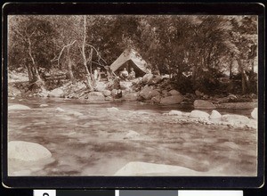 Fishing club members on the edge of a mountain stream near a tent, ca.1910-1920