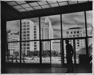 Standing in the main lobby of the Los Angeles County Courthouse building, guard Ira Reuben gets impressive picture window view of Civic Center, 1958
