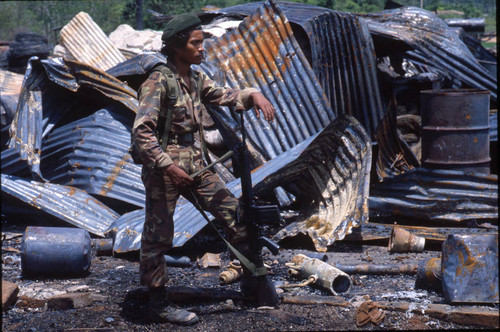 Contra soldier leans on firearm, Honduras, 1983