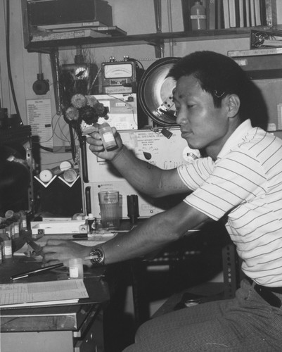 Masuru Kono, a paleomagnetist from the Geophysical Institute, University of Tokyo, examines a core sample prior to magnetic analysis aboard the D/V Glomar Challenger (ship) during Leg 55 of the Deep Sea Drilling Project. 1977