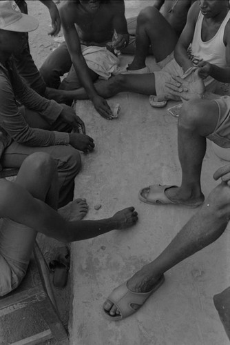 Men playing a game on sidewalk, San Basilio de Palenque, ca. 1978