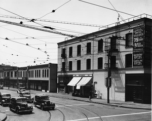 From the corner of Ninth Street and Main Street, cars and trolley car wires are seen