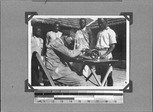Missionary Giersch sitting at a sewing machine, Tanzania, ca.1906-1929