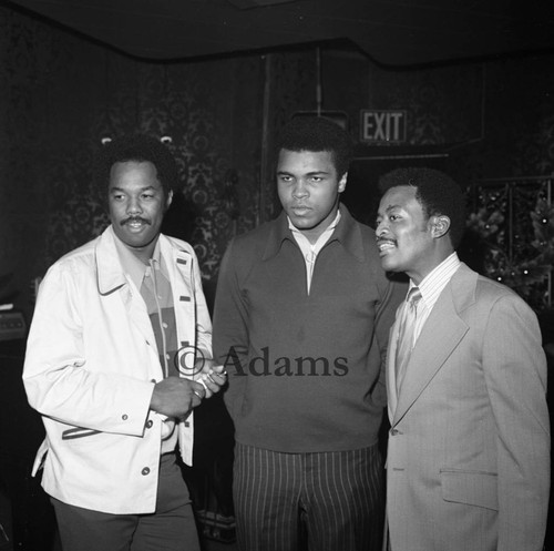 Muhammad Ali, Johnny Cochran, and Howard Bingham talking at the Pied Piper nightclub, Los Angeles, 1970