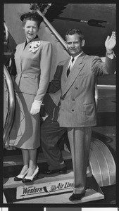 University of Southern California track coach Jess Hill waving as he boards a plane with his wife, Los Angeles Airport, 1948