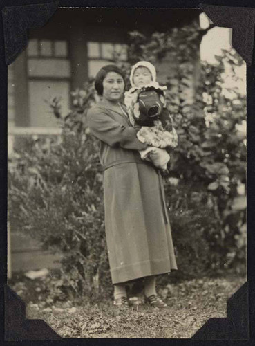 Woman holding baby outside