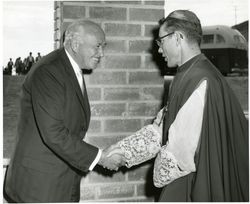 Conrad Hilton shaking hands with Timothy Cardinal Manning