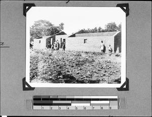 People in front of a newly built house, Utengule, Tanzania, 1937