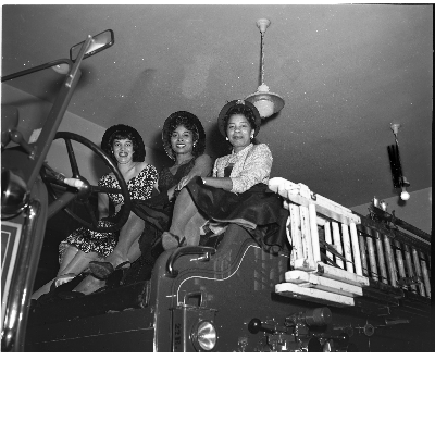 Three women sitting in fire truck
