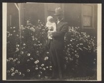 E. E. Wood and Ernestine Wood in front of flowering shrub, date unknown
