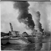 Smoke rises over the damage done to a marine terminal after the Markay oil tanker exploded in L.A. Harbor, Los Angeles, 1947