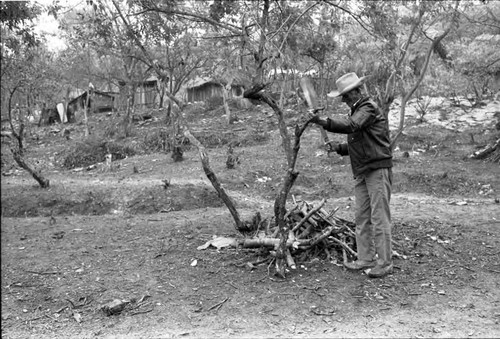 Older refugee man creating small logs, Chiapas, 1983