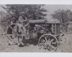 Henry Plummer driving a tractor on his dairy, Chileno Valley, Petaluma, California, in the 1920s