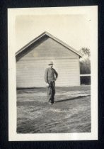 Man in front of Winchester outbuilding