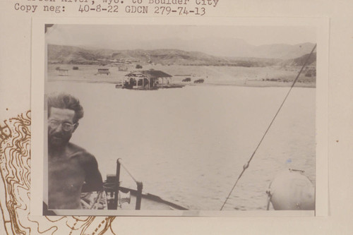 The floating dock at Pierce Ferry with Charles Larabee showing at left margin. Larabee was in the Nevills party which cruised from Green River, Wyoming, to Boulder City