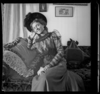 Daisy Kellum poses on a sofa in her home, Los Angeles, about 1899