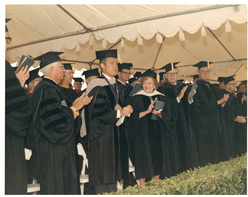 Center L to R: Dr. William Banowsky, Mr. Richard Seaver, Mrs. Seaver under the big white tent all in academic robes (Color)