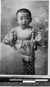 Child standing by a rock, Japan, ca. 1920-1940