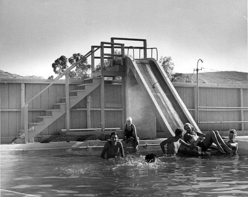 Water slide at Brandeis Camp Institute with Betty Taksar Beiner sitting on pool edge