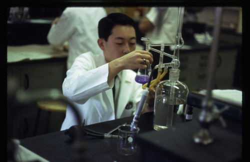 Student in drug analysis lab using Erienmeyer flask 