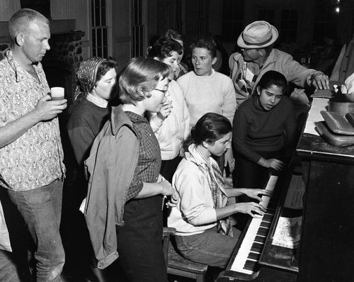 Students gathered around a piano