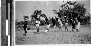 Eight men threshing a field, Africa, April 1947