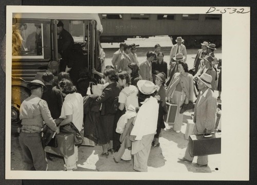 This group arrived by train from Elk Grove, California, and are boarding a bus for Manzanar, a War Relocation Authority center where evacuees of Japanese ancestry will spend the duration. Photographer: Stewart, Francis Manzanar, California