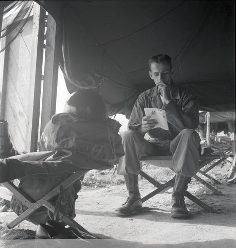 Soldier reading inside a military camp
