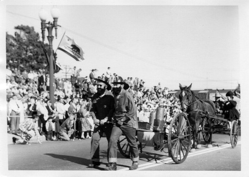 South San Francisco Bicentennial Parade - old time firemen, pulling wagon; horsedrawn wagon following (1958)