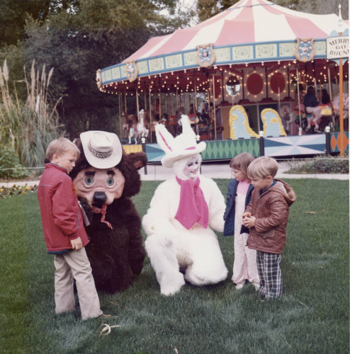 Theodore the bear and the Easter Bunny sitting on grass at Frontier Village