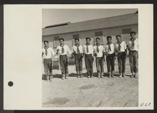 Members of the drum and bugle corps, formerly a boy scout troop at Los Angeles, pose for their photograph at the Topaz Relocation Center. Photographer: Parker, Tom Topaz, Utah