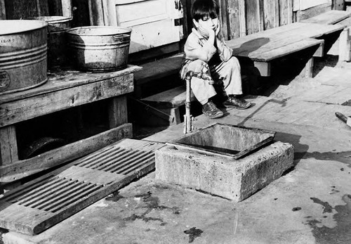 Child on porch with basins