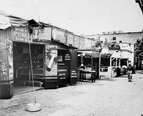 Photograph of Olvera Candle Shop, Hand Writing Analysis booth and a few other booths on Olvera street