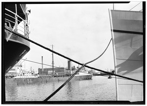 View of a harbor from the crossed ropes of two anchored ships, ca.1930-1939