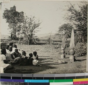 Children sitting in front of a "hazomboto", Ankomake, Mikoboke, Madagascar, 1936