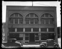 Two vehicles parked in front of the old "Post-Record" building, Los Angeles, 1930s