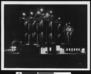 Exterior view of an unidentified oil refinery at night, ca.1940
