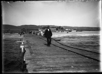 Man on pier with fishermen, c. 1906