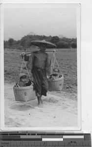 A man carrying two babies at Wuzhou, China, 1944