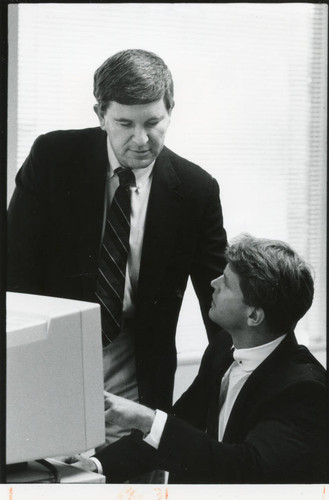 Photograph of Dr. James Martinoff assisting a student at his computer--EMBA