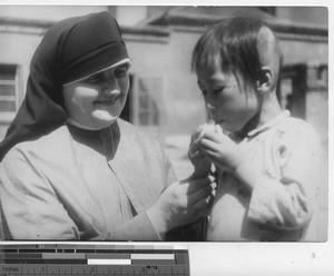 Maryknoll Sister with an orphan at Fushun, China, 1937
