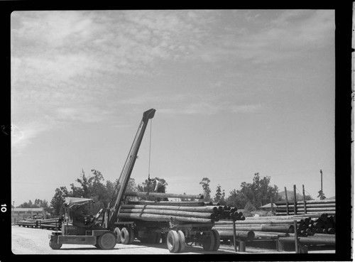 Loading poles on trucks at CEP Pole Yard