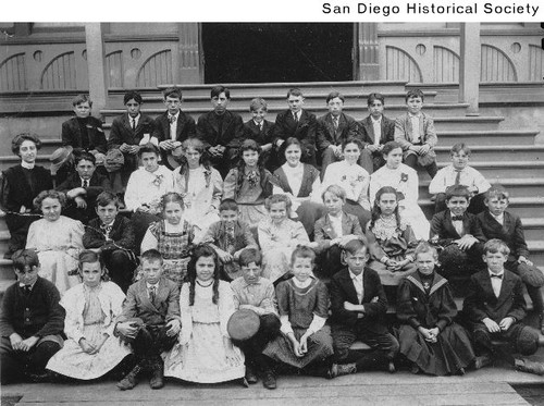 Group of children seated on the steps of a building