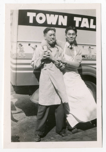 Two men leaning on truck