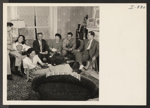 This group of resettlers is gathered in the attractively furnished living room of Mr. and Mrs. Eishichiro George Koiwai, Issei