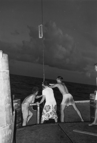 Theodore Robert Folsom, unidentified man, and Milton Nunn Bramlette launch a water sampler