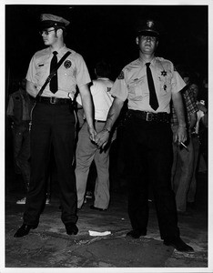 Two men dressed as police officers holding hands